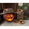 A fall table display with a handmade apple decoration lit with a candle.It is a real gourd with a happy face carved into it. 